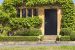 Brown wooden doors to traditional English stoned cottage, garden
